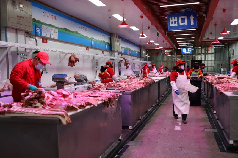 Vendors sell pork at the Xinfadi wholesale market in Beijing