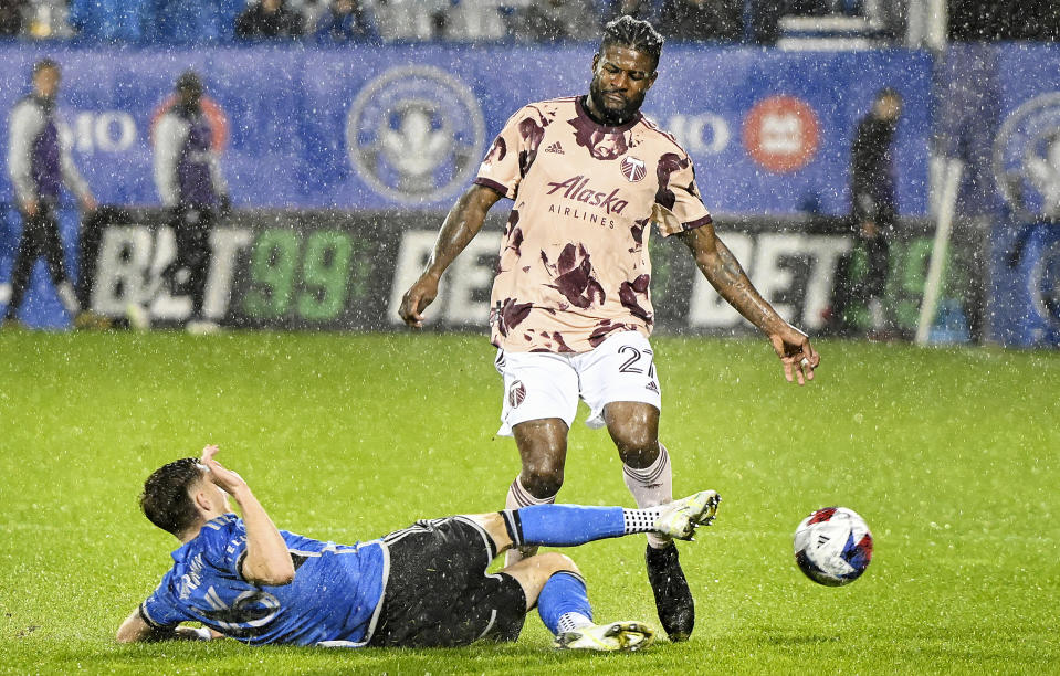 CF Montreal's Joel Waterman, left, challenges Portland Timbers' Dairon Asprilla, right, during second-half MLS soccer match action in the rain in Montreal, Saturday, Oct. 7, 2023. (Graham Hughes/The Canadian Press via AP)