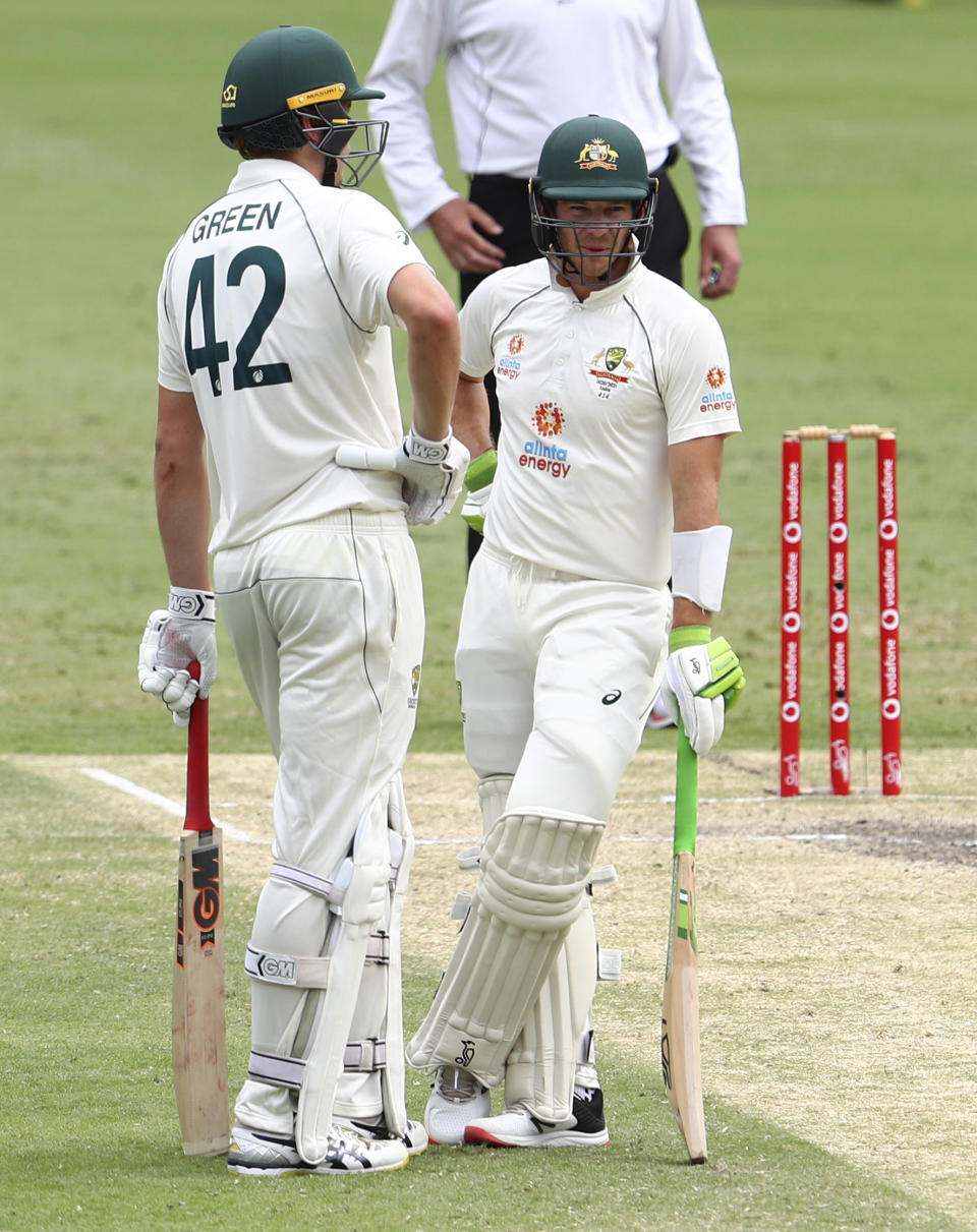 Australian captain Tim Paine talks with batting partner Cameron Green, left, during play on day four of the fourth cricket test between India and Australia at the Gabba, Brisbane, Australia, Monday, Jan. 18, 2021. (AP Photo/Tertius Pickard)