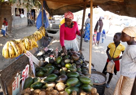 A street vendor sells vegetables at a market place in Chitungwiza, Zimbabwe