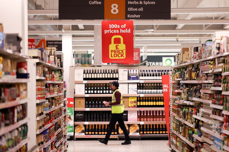 FILE PHOTO: An employee walks inside a Sainsbury’s supermarket in Richmond, west London