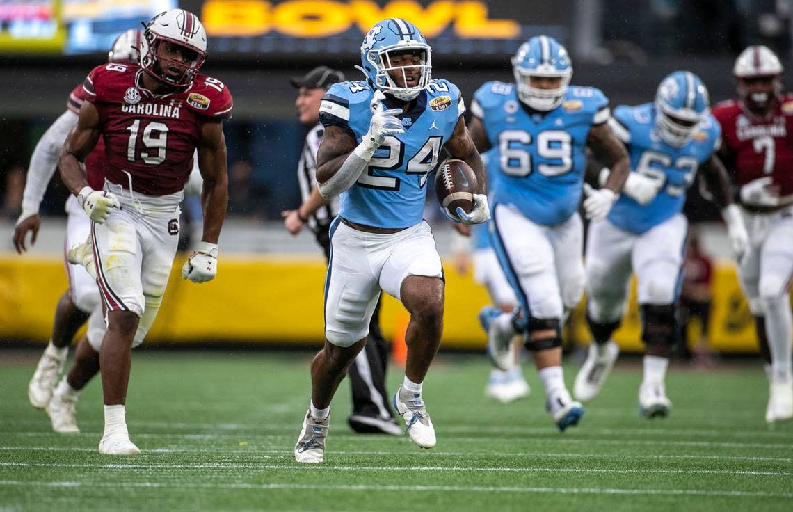 North Carolina’s British Brooks (24) races 63 yards for a touchdown in the second quarter against South Carolina in the Duke’s Mayo Bowl on Thursday, December 30, 2021 at Bank of America Stadium in Charlotte, N.C.