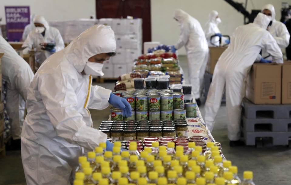 In this handout photo provided by Istanbul Mayor's office, workers prepare the food packages they have prepared for city's residents in need amid the coronavirus outbreak, in Istanbul, Friday, April 3, 2020. The new coronavirus causes mild or moderate symptoms for most people, but for some, especially older adults and people with existing health problems, it can cause more severe illness or death.(Istanbul Mayor's Office via AP)