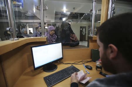 Palestinians returning to Gaza wait to stamp their passports at the Rafah border crossing between Egypt and southern Gaza Strip November 26, 2014. REUTERS/Ibraheem Abu Mustafa