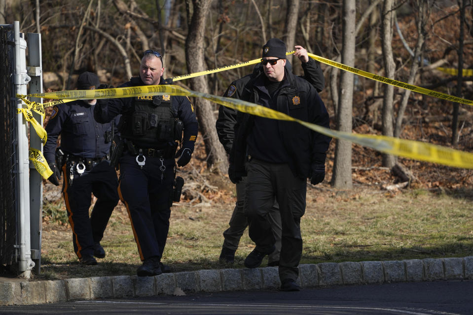 CORRECTS TO THE PARLIN AREA OF SAYREVILLE - Police officers and detectives investigate a wooded area near a townhome community, Thursday, Feb. 2, 2023, in the Parlin of Sayreville, N.J., where Sayreville councilwoman Eunice Dwumfour was found shot to death in an SUV parked outside her home on Wednesday. According to the Middlesex County prosecutor's office, she had been shot multiple times and was pronounced dead at the scene. (AP Photo/Seth Wenig)
