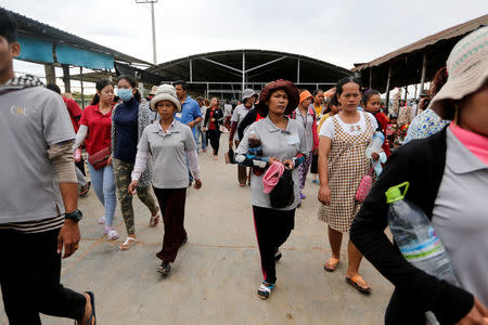 Workers arrive early morning for their shift at Complete Honour Footwear Industrial, a footwear factory owned by a Taiwan company, in Kampong Speu, Cambodia, July 5, 2018. REUTERS/Ann Wang