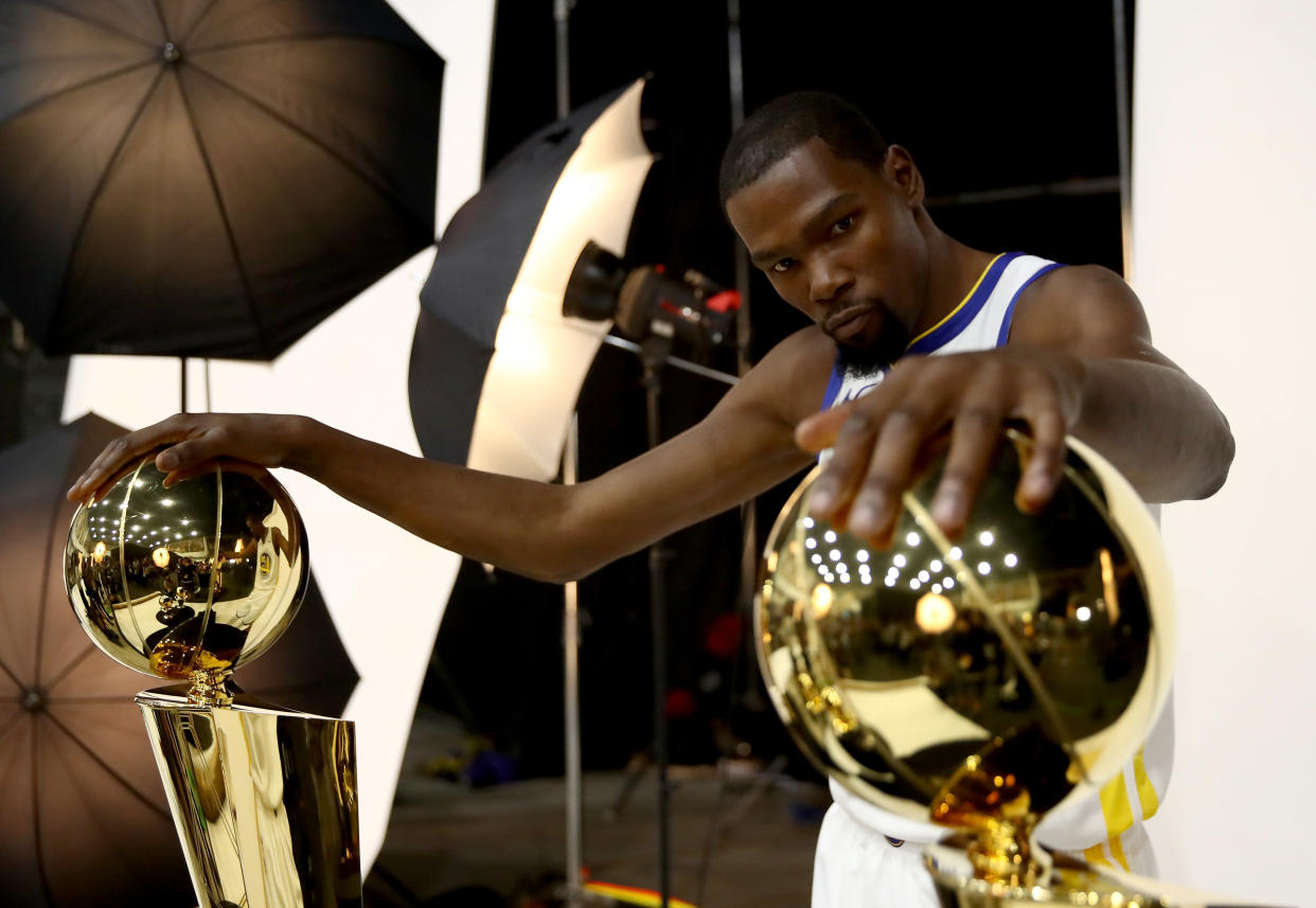 OAKLAND, CA - SEPTEMBER 24:  Kevin Durant #35 of the Golden State Warriors poses with two Larry O'Brien NBA Championship Trophies and two NBA Finals MVP trophies during the Golden State Warriors media day on September 24, 2018 in Oakland, California.  (Photo by Ezra Shaw/Getty Images)