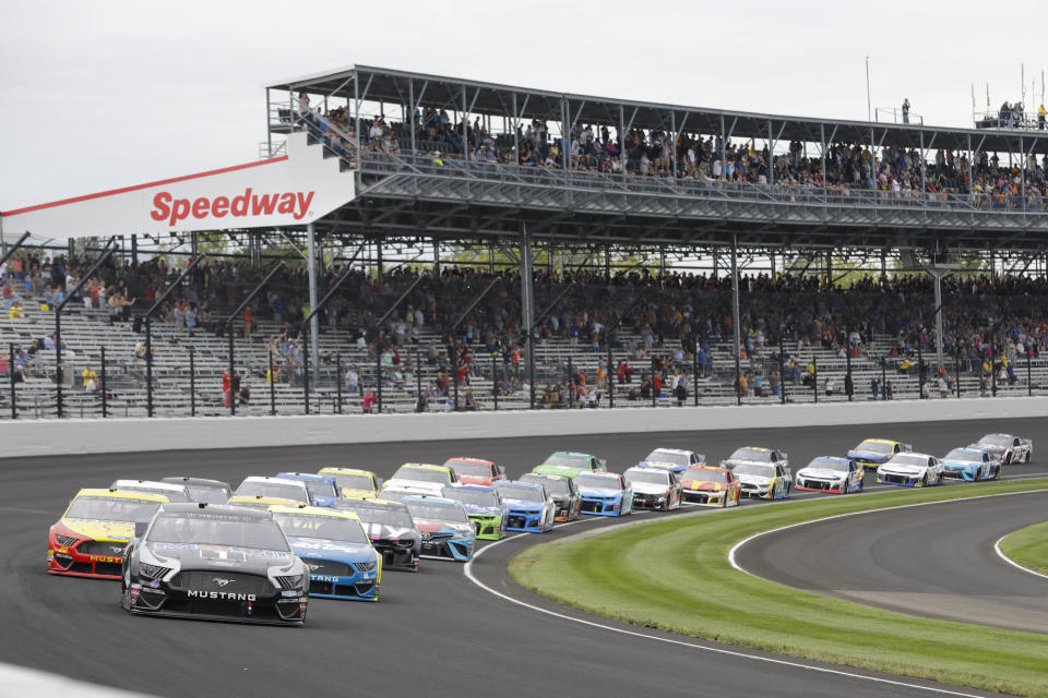 FILE - In this Sept. 8, 2019, file photo, Kevin Harvick leads the field through the first turn on the start of the NASCAR Brickyard 400 auto race at Indianapolis Motor Speedway in Indianapolis. The once frosty schism between the two biggest racing series in the United States has thawed and NASCAR's elite Cup Series will share a venue with IndyCar on the same weekend for the first time in history. (AP Photo/Darron Cummings, File)