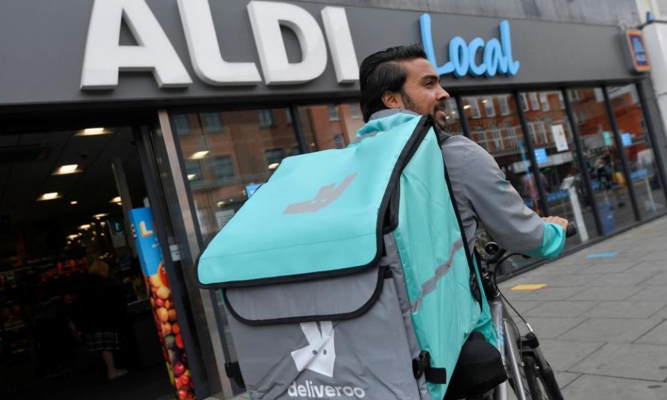 A Deliveroo delivery rider with a bag of Aldi groceries in London.