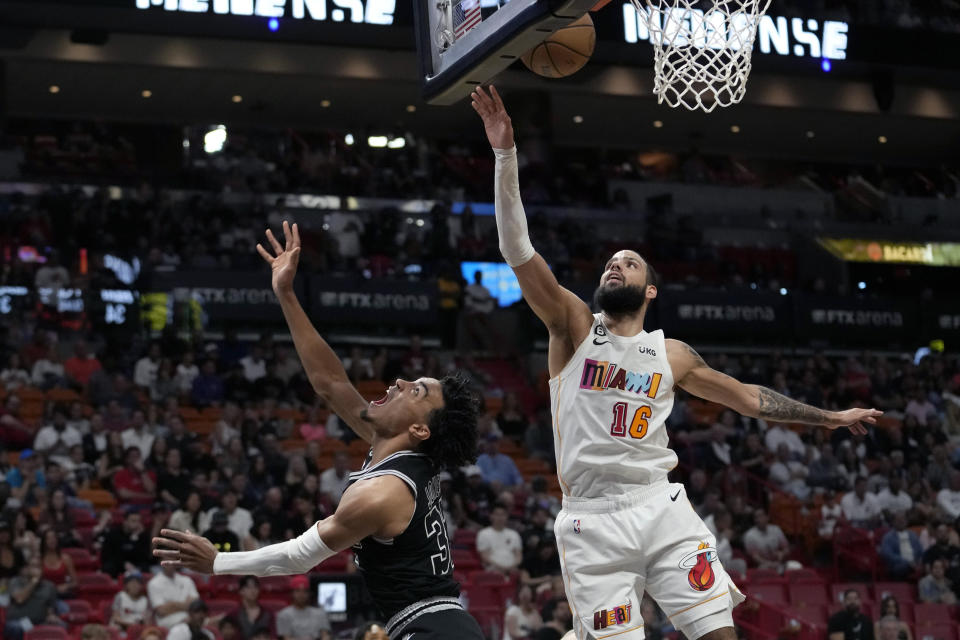 San Antonio Spurs guard Tre Jones, left, shoots over Miami Heat forward Caleb Martin (16) during the first half of an NBA basketball game, Saturday, Dec. 10, 2022, in Miami. (AP Photo/Lynne Sladky)