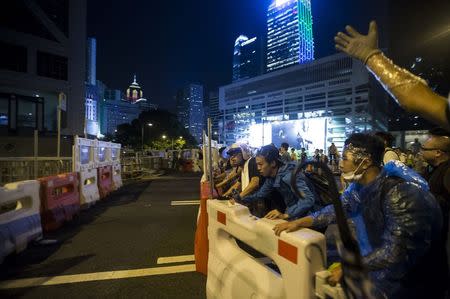 Protesters push a traffic barrier to block the main street to the financial Central in Hong Kong September 28, 2014. REUTERS/Tyrone Siu