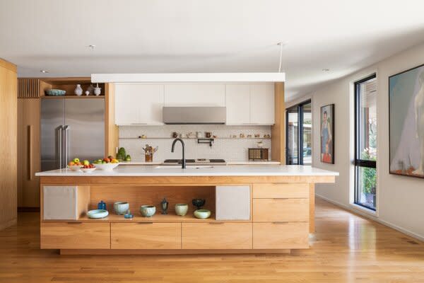 The home's original butternut paneling in the kitchen inspired new white oak cabinetry for its open plan layout.