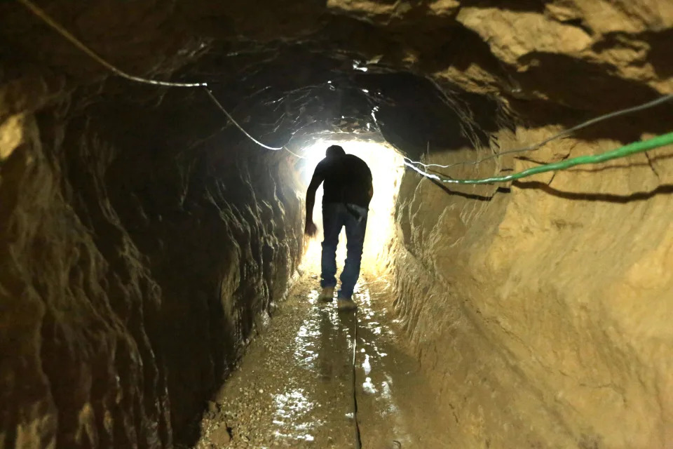 A Palestinian man walks from the Egyptian side of the border in a repaired bombed smuggling tunnel linking the Gaza Strip to Egypt, in Rafah, in this file photo from 2012.