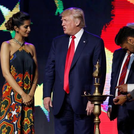 Republican presidential nominee Donald Trump (C) gets help lighting a ceremonial diya lamp before he speaks at a Bollywood-themed charity concert put on by the Republican Hindu Coalition in Edison, New Jersey, U.S. October 15, 2016. REUTERS/Jonathan Ernst