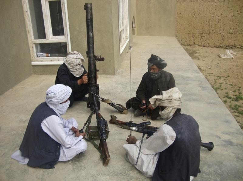 Taliban fighters pose with weapons as they sit in their compound at an undisclosed location in southern Afghanistan in this May 5, 2011 file picture.  REUTERS/Stringer