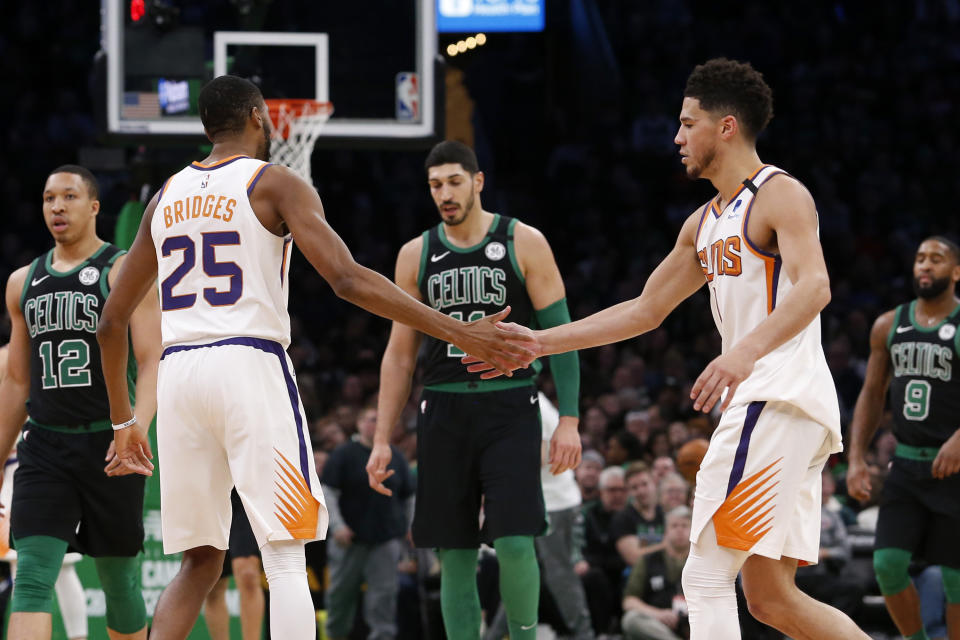 Phoenix Suns guard Devin Booker, right, celebrates with Mikal Bridges, left, during the second half of an NBA basketball game against the Boston Celtics, Saturday, Jan. 18, 2020, in Boston. (AP Photo/Mary Schwalm)