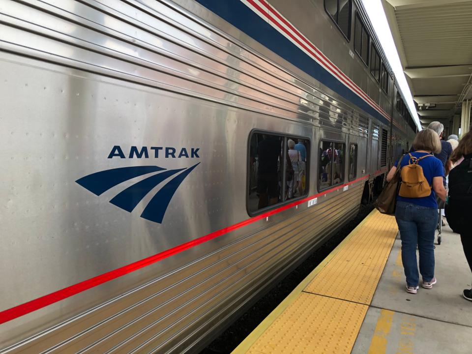 Silver Amtrak train with logo on side of the train