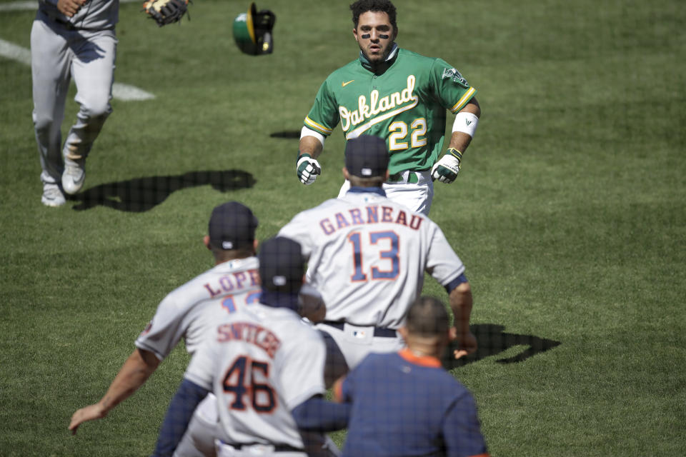 Oakland Athletics' Ramon Laureano (22) charges the Houston Astros' dugout after being hit by a pitch thrown by Humberto Castellanos during the seventh inning of a baseball game Sunday, Aug. 9, 2020, in Oakland, Calif. (AP Photo/Ben Margot)