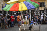 Residents wait to be inoculated with COVID-19 vaccines outside a school during the first day of a nationwide three-day vaccination drive in Quezon city, Philippines on Monday, Nov. 29, 2021. There has been no reported infection so far caused by the new variant in the Philippines, a Southeast Asian pandemic hotspot where COVID-19 cases have considerably dropped to below 1,000 each day in recent days, but the emergence of the Omicron variant has set off a new alarm. (AP Photo/Aaron Favila)