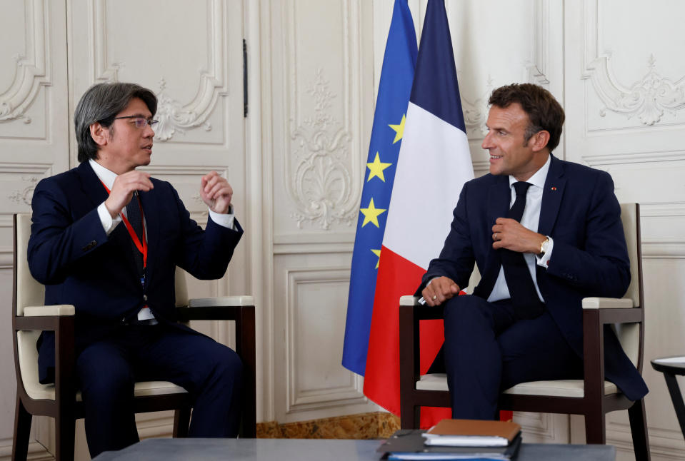 France's President Emmanuel Macron speaks with ProLogium's CEO Vincent Yang during a meeting as part of the 5th edition of the 