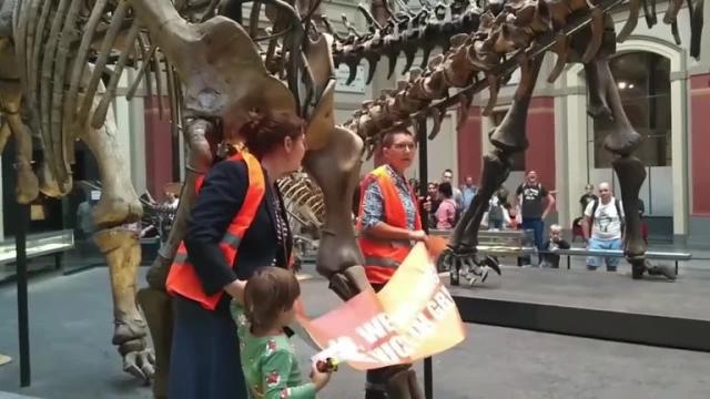 Con un niño de la mano, dos activistas se pegaron al esqueleto de un  dinosaurio en un museo de Berlín