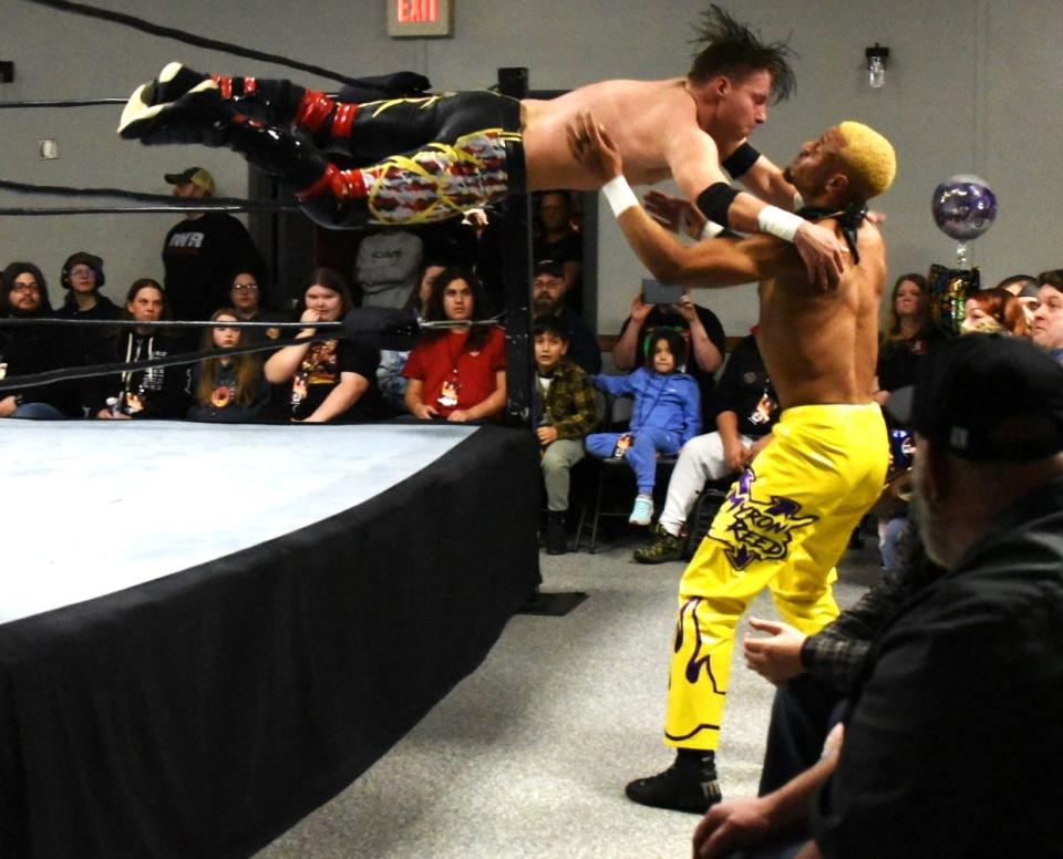 Professional wrestler KJ Reynolds leaps out of the ring into Myron Reed at an Insane Wrestling Revolution match held at the Ottawa County Fairgrounds on Wednesday night.