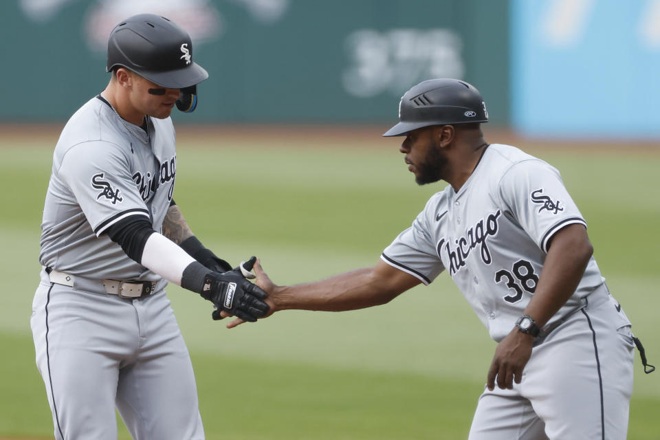 Chicago White Sox designated hitter Korey Lee celebrates with Chicago White Sox first base coach Jason Bourgeois (38) after hitting an RBI single off Cleveland Guardians pitcher Logan Allen during the first inning of a baseball game, Tuesday, April 9, 2024, in Cleveland. (AP Photo/Ron Schwane)