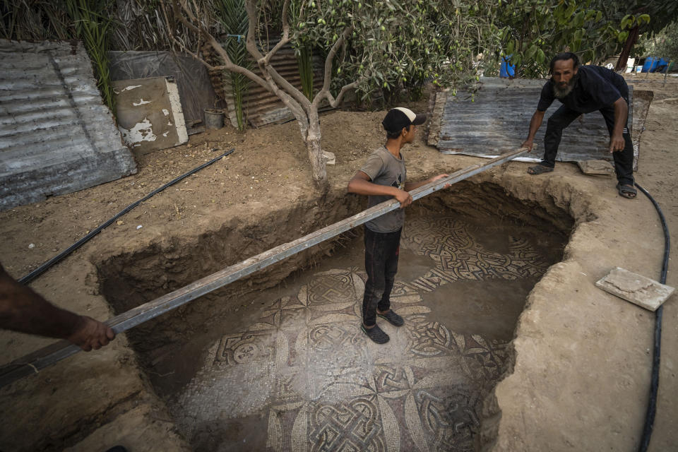 Trabajadores limpian un piso de mosaicos antiguos de la era bizantina descubierto por un campesino palestino en Bureij (Franja de Gaza). Foto del 5 de septiembre del 2022. (AP Photo/Fatima Shbair)