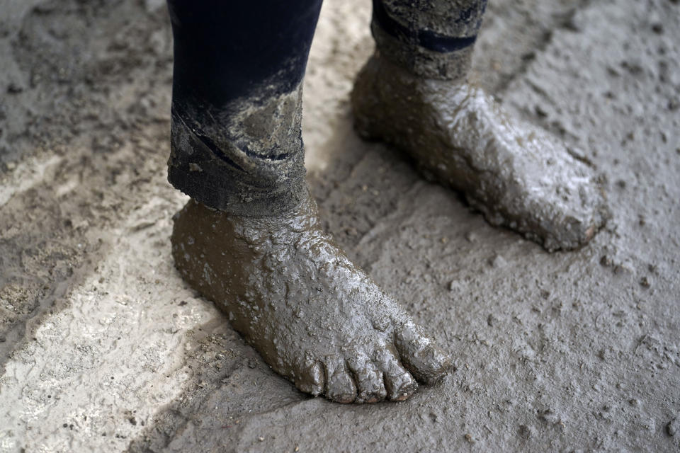 Los pies de Perla Halbert cubiertos de fango después de que intentó, sin éxito, llegar a su casa tras un deslave, el martes 13 de septiembre de 2022, en Oak Glen, California. (AP Foto/Marcio Jose Sanchez)