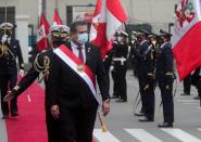 Peru's interim President Manuel Merino reviews an honour guard after he was sworn in following the removal of President Martin Vizcarra by lawmakers, in Lima