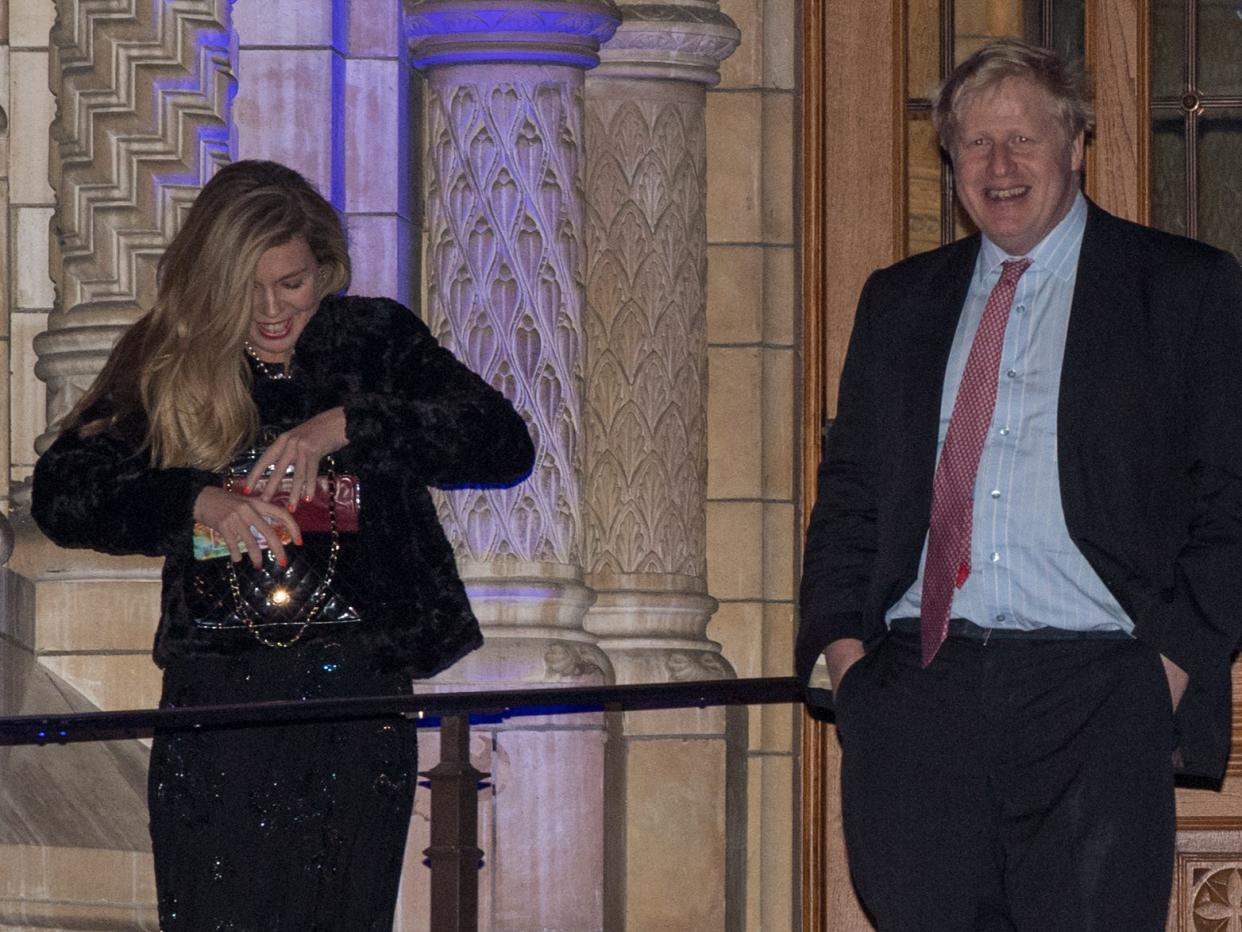 Foreign Secretary Boris Johnson passes Carrie Symonds as he leaves the Conservative party Black and White Ball at Natural History Museum on February 7, 2018 i