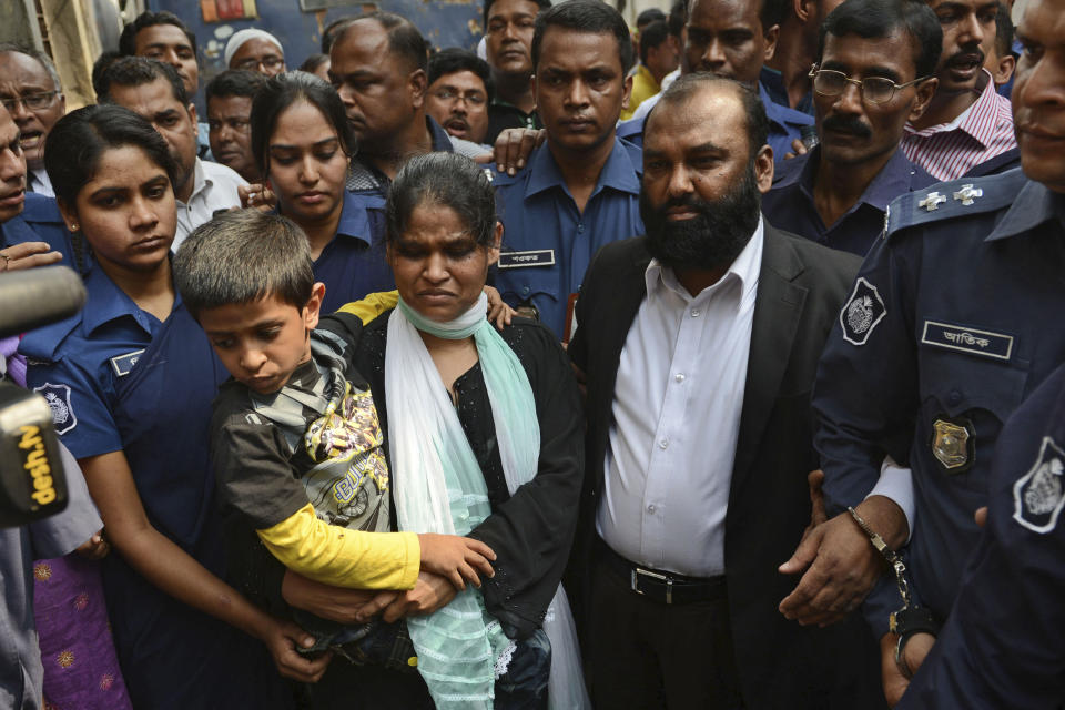 Two owners of Tazreen Fashions Ltd., Delwar Hossain, center left, and his wife, Mahmuda Akter, right, are escorted by security personnel to a court in Dhaka, Bangladesh, Sunday, Feb. 9, 2014. The owners of a Bangladesh garment factory where 112 workers died in a fire two years ago surrendered on Sunday and sought bail after they were charged with homicide. (AP Photo)