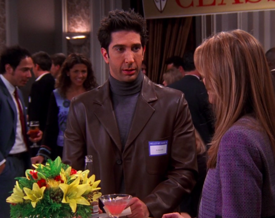 Ross wearing slacks, a turtleneck, and a big leather jacket