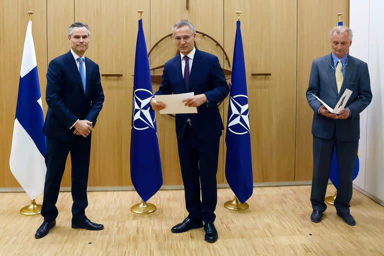 El embajador de Finlandia ante la OTAN, Klaus Korhonen, el secretario general de la OTAN, Jens Stoltenberg, y el embajador de Suecia ante la OTAN, Axel Wernhoff, asisten a una ceremonia para marcar la solicitud de ingreso de Suecia y Finlandia en Bruselas, el 18 de mayo de 2022.