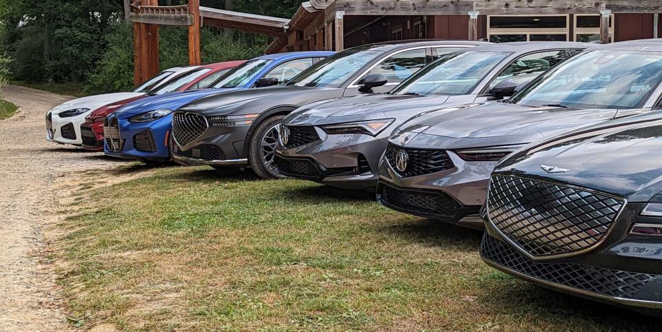 a lineup of luxury cars awaiting car and driver editors' evaluation