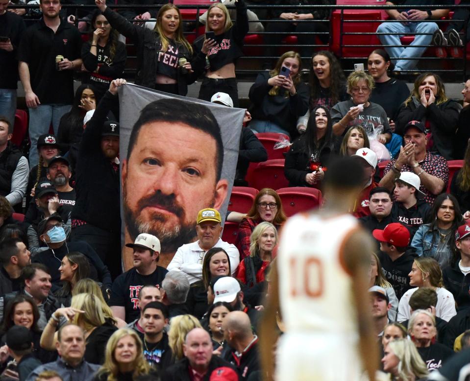 Texas Tech fans hold a poster of former Texas basketball coach Chris Beard's booking mug shot during their game in Lubbock on Feb. 13. Beard, who left Tech for UT in 2021, had been fired in January after his arrest on domestic violence charges, which were eventually dropped.