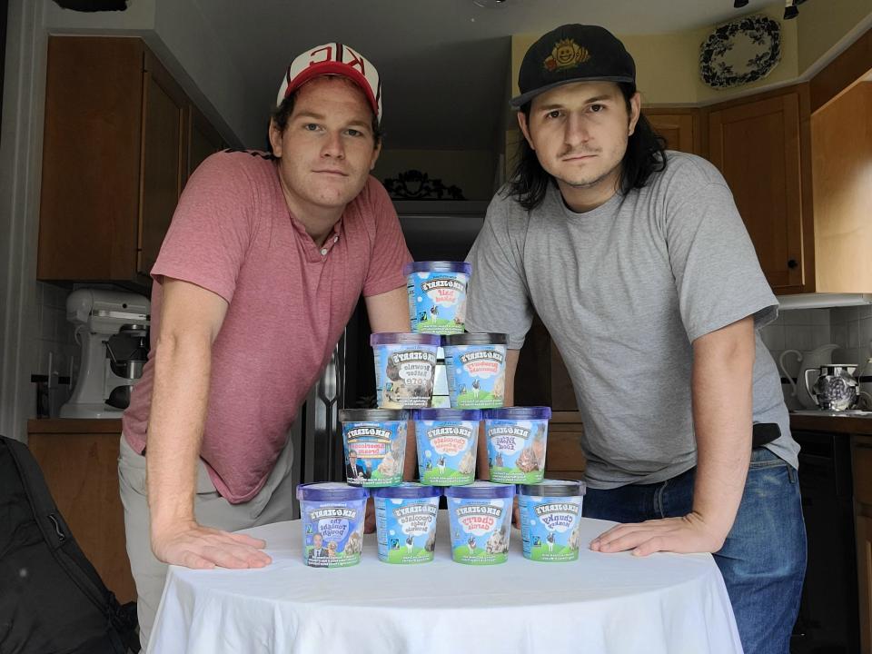 Clayton and Lucien standing in front of table with pile of Ben & Jerry's ice cream