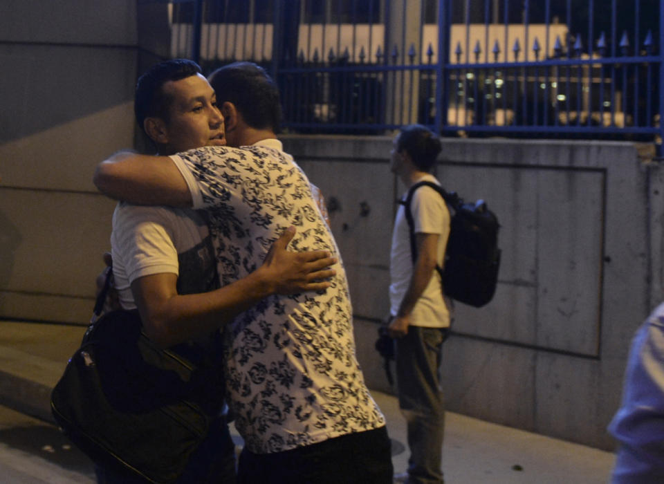 Dos personas se abrazan en el exterior de la terminal (AP).
