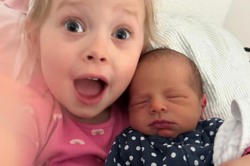 Nell couldn't be happier as she cuddled her new baby brother