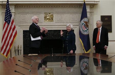 Federal Reserve Board Governor Daniel Tarullo (L) applauds new Federal Reserve Board Chairwoman Janet Yellen (C) after administering the oath of office to Yellen as her husband George Akerlof (R) looks on at the Federal Reserve Board in Washington, February 3, 2014. REUTERS/Jim Bourg