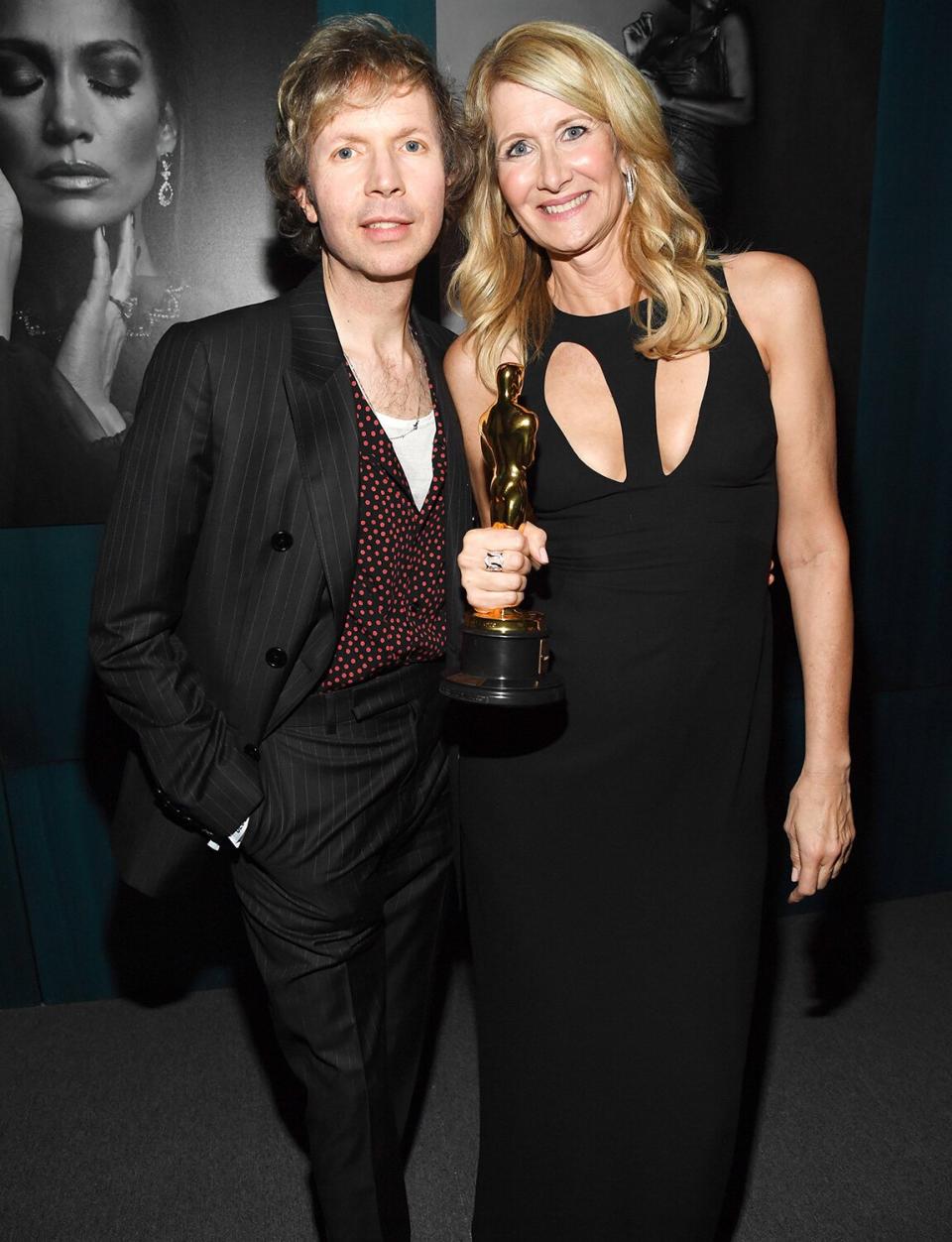 Laura Dern holds onto her Oscar for <em>Marriage Story </em>as she poses with Grammy Award-winning artist, Beck. 