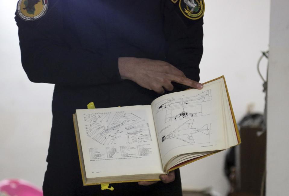 In this Friday, Jan. 27, 2017 photo, an Iraqi officer holds a book was found in a drones workshop belonging to Islamic State militants in Mosul, Iraq. Islamic State is hacking store-bought drone technology, using rigorous testing and tactics that mimic those used by U.S. unmanned aircraft to adapt to diminishing numbers of fighters and a battlefield that is increasingly difficult to navigate on the ground. (AP Photo/Khalid Mohammed)