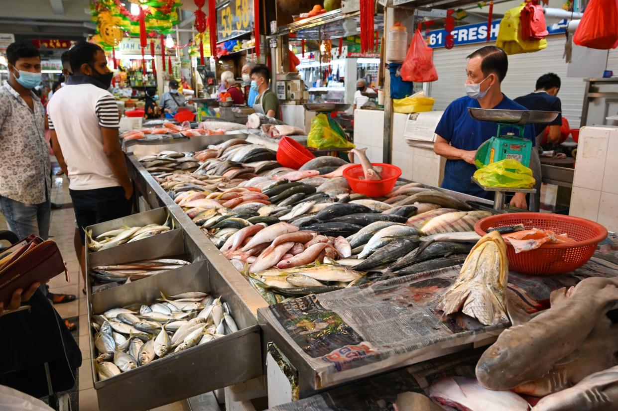 People shop for fish at a wet market in Singapore. 