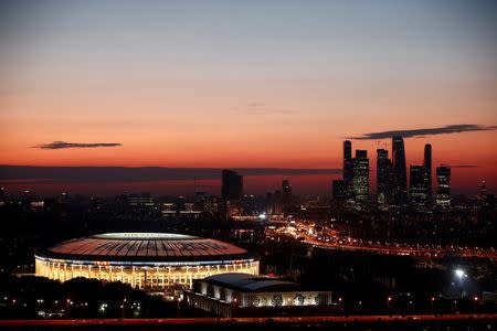 The illuminated Luzhniki stadium and the skyscrapers of the Moscow International Business Centre, also known as "Moskva-City", are seen just after sunset before the upcoming World Cup final between France and Croatia in Moscow, Russia July 12, 2018. Picture taken July 12, 2018. REUTERS/Christian Hartmann