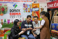 Visitors gather information at a booth on packaging services at the China Import and Export Fair in Guangzhou, China April 17, 2017. REUTERS/Venus Wu