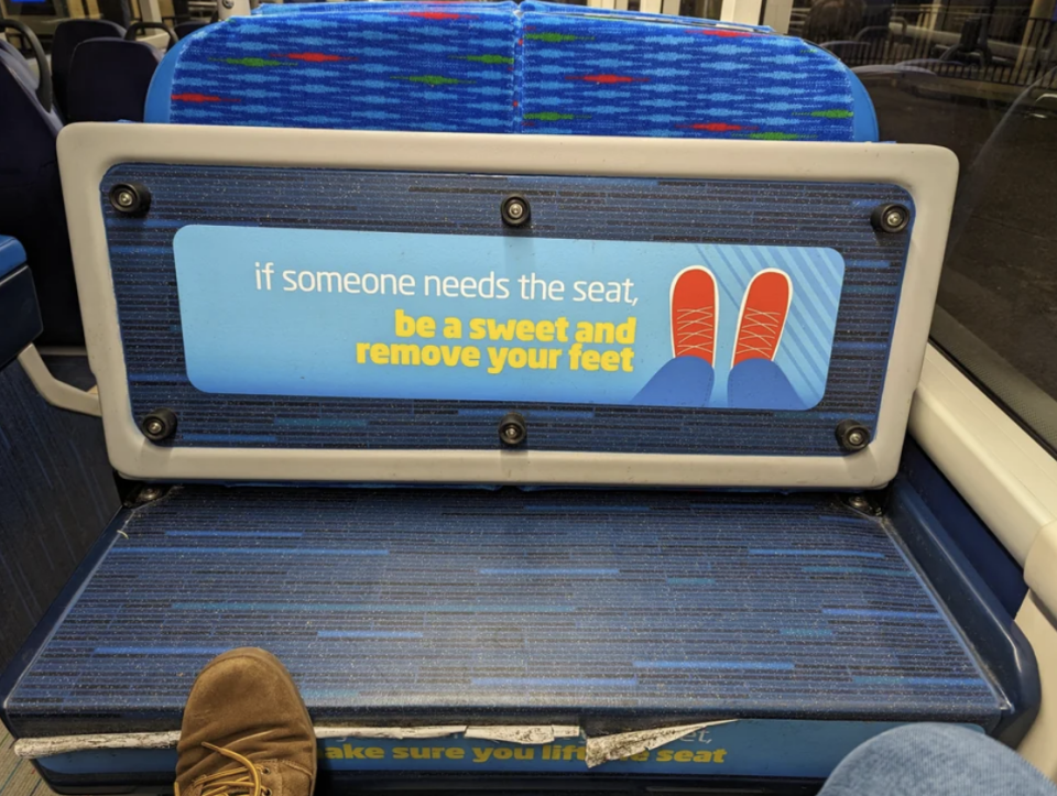 Sign on bus seat reads "if someone needs the seat, be a sweet and remove your feet" with a graphic of shoes on a seat