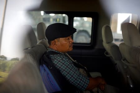 A migrant from Guatemala waits inside a van after he was detained at a checkpoint on a road in Tuxtla Chico