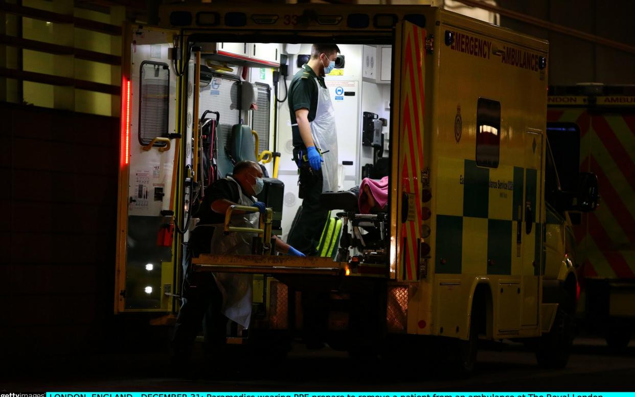 Paramedics wearing PPE prepare to remove a patient from an ambulance at The Royal London Hospital on December 31, 2020  -  Hollie Adams/Getty Images Europe