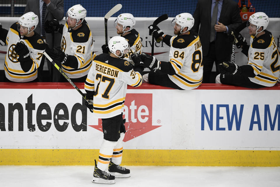 Boston Bruins center Patrice Bergeron (37) celebrates his goal with the bench during the second period in Game 5 of an NHL hockey Stanley Cup first-round playoff series against the Washington Capitals, Sunday, May 23, 2021, in Washington. (AP Photo/Nick Wass)