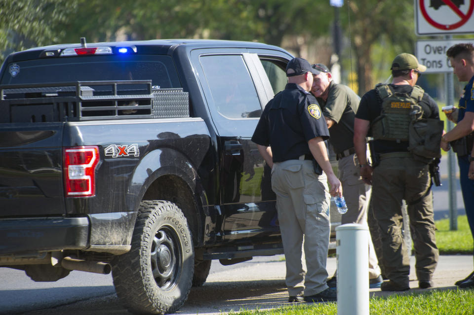 A Department of Corrections K-9 unit truck sits parked after arriving near the parking lot of the Willowbrook Center shopping area at Hoo Shoo Too Road and Jefferson Highway, Saturday, Oct. 9, 2021, after a male suspect exchanged fire near there with a Louisiana State Trooper earlier in the day. (Travis Spradling/The Advocate via AP)